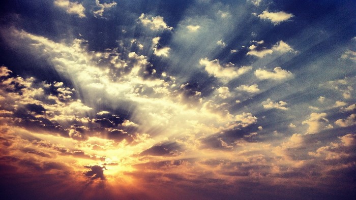 Sunbeams shining through clouds in the sky