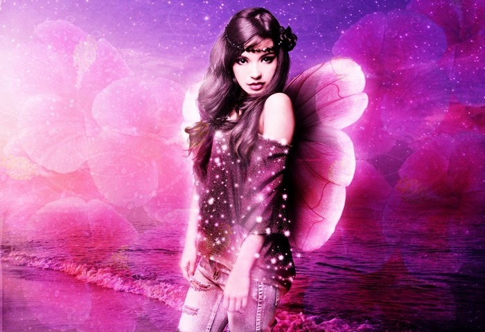 Fairy girl with pink wings on a beach