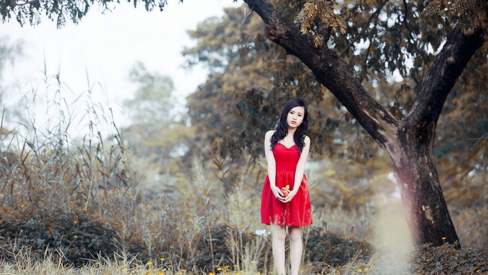 Young Asian woman in red dress holding an apple