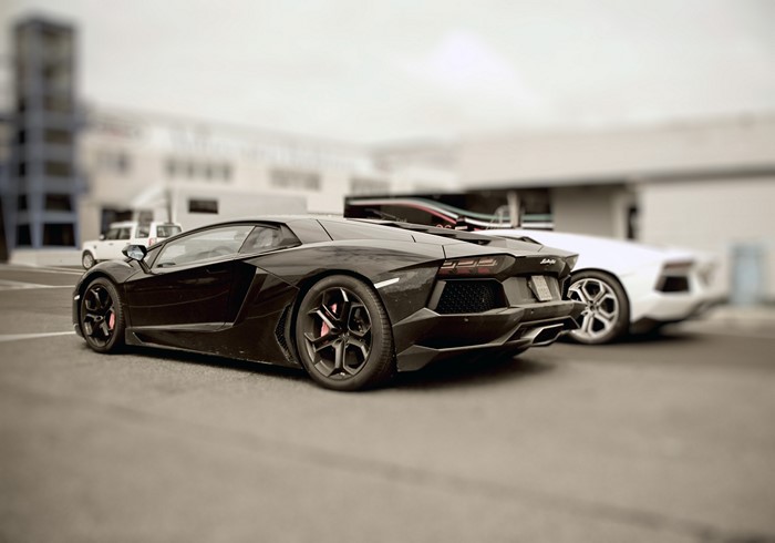 Black Lamborghini Aventador and white Lamborghini