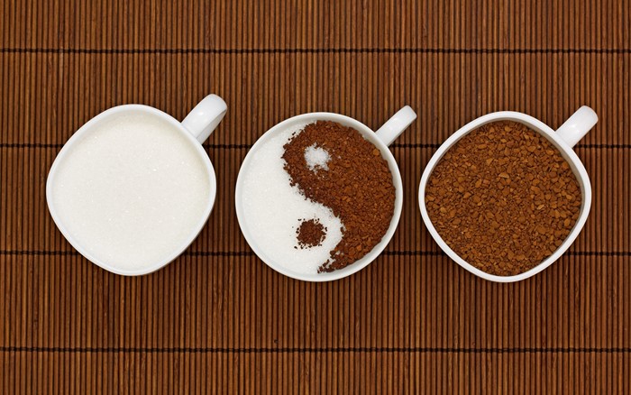 Coffee and sugar in cups on bamboo mat