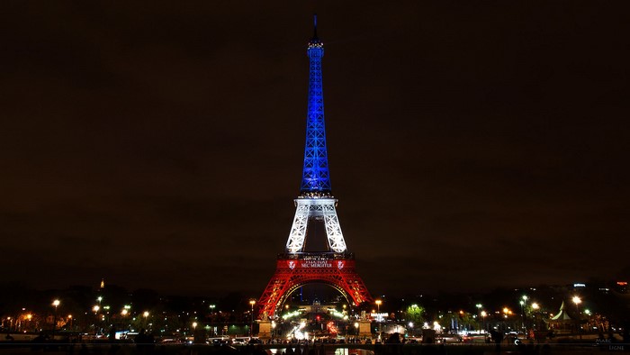 Eiffel Tower illuminated in French flag colors at night