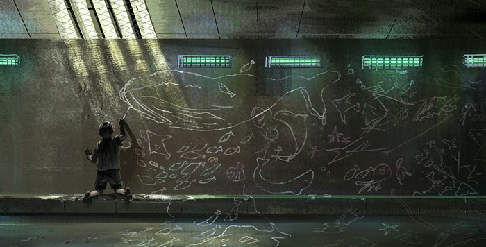 Boy drawing sea creatures on a wall