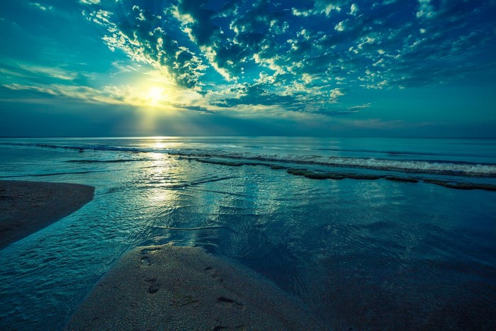 Beach with ocean waves and sun