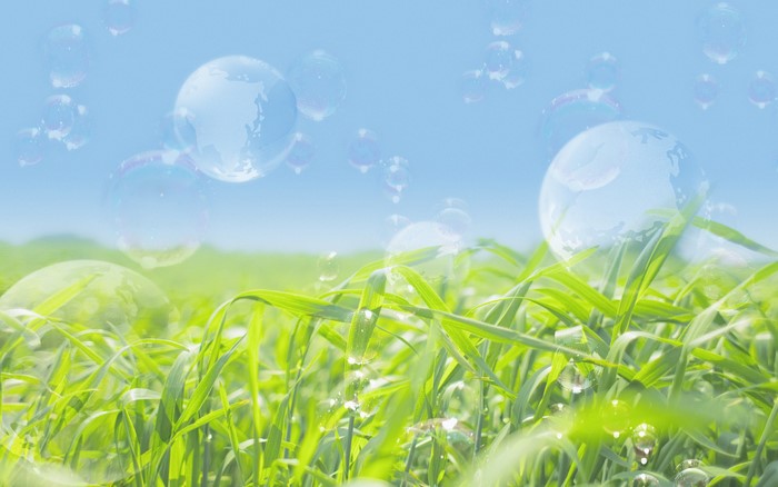 Bubbles floating over a green field and blue sky