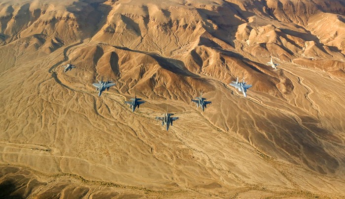 Fighter jets flying over a desert landscape