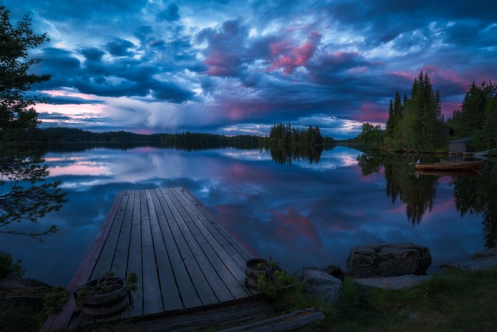 Wooden pier on a lake at sunset with colorful clouds
