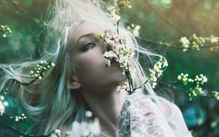 Woman with white hair and flowers in a forest