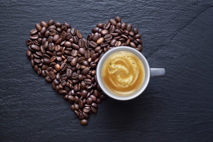 Heart shape made of coffee beans with a cup of coffee
