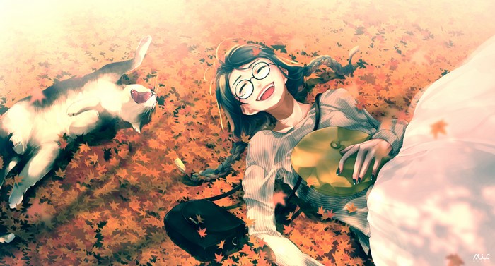 Girl and cat lying in autumn leaves