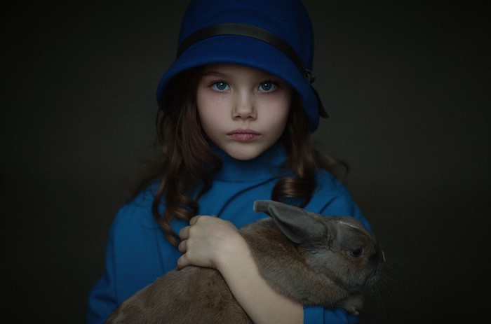 Girl in blue hat holding a rabbit