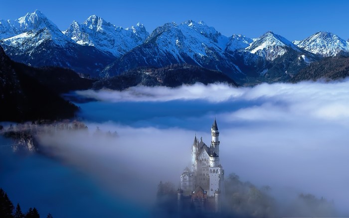 Neuschwanstein Castle in Fog with Snowy Mountains