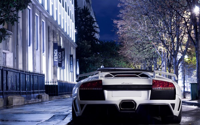 White Lamborghini parked on a street at night