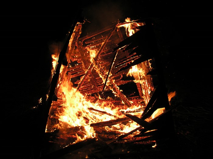Structure engulfed in flames at night