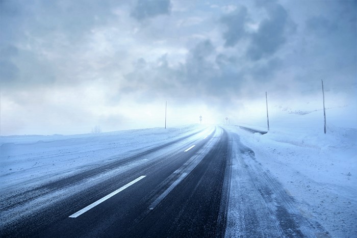 Road covered in snow during a winter storm