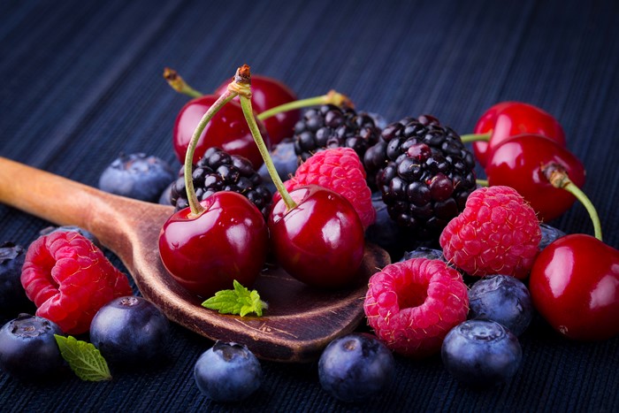 Assortment of fresh berries on a wooden spoon