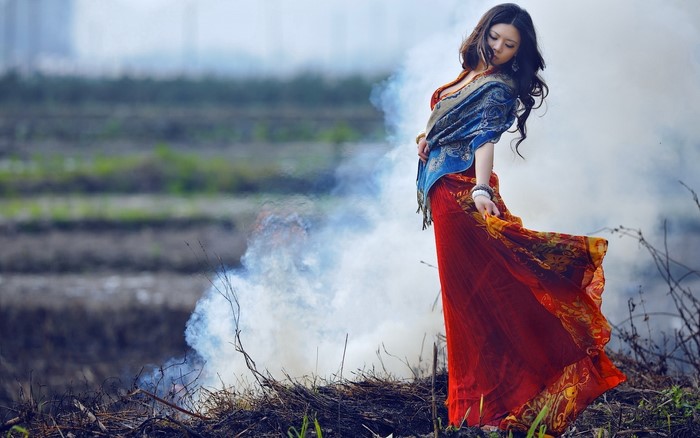 Woman in red dress and blue shawl in a field