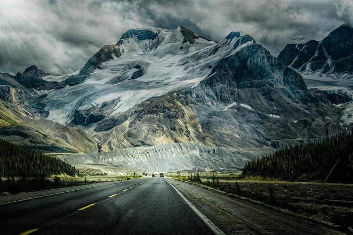 Road leading to a vast glacier and mountains