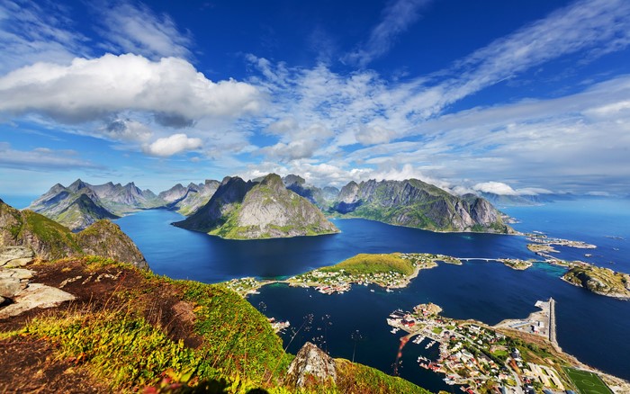 Aerial view of a coastal town nestled among mountains and fjords