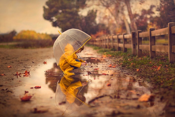 Little Girl in Yellow Raincoat with Umbrella by Puddle