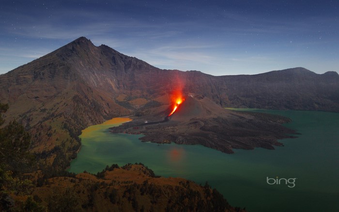 Volcano erupting into a lake at night