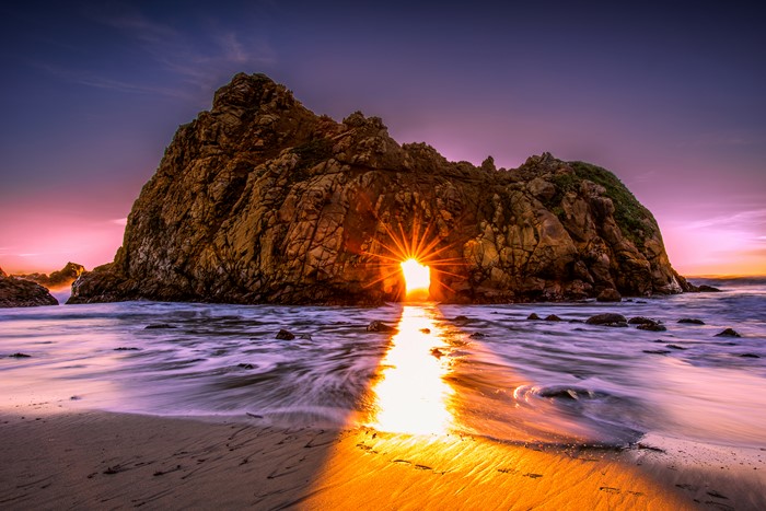 Sunset through rock arch at Pfeiffer Beach