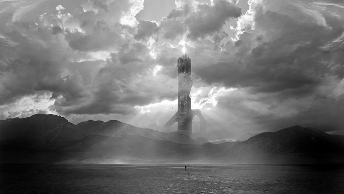 Black and white tower in clouds over mountains