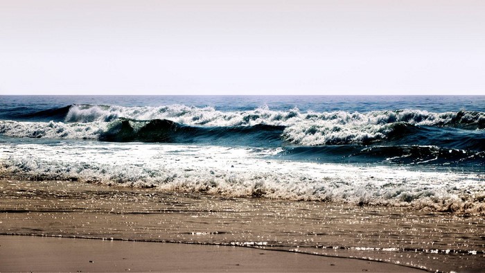 Ocean waves crashing on a sandy beach