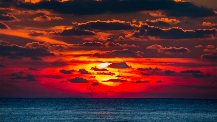 Sunset over the ocean with dramatic clouds