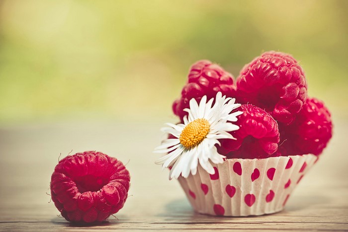 Raspberries in a cupcake liner with a daisy
