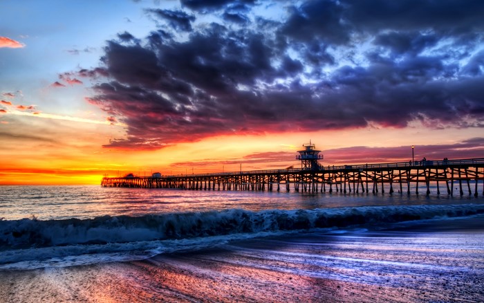 Sunset over the ocean with a pier