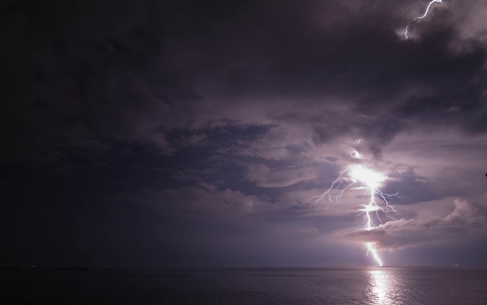 Lightning strikes the ocean during a storm