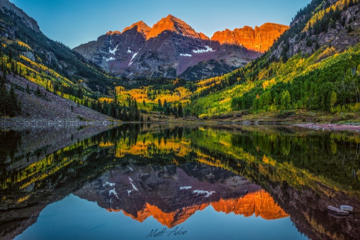 Maroon Bells mountains reflected in lake at sunrise, Colorado