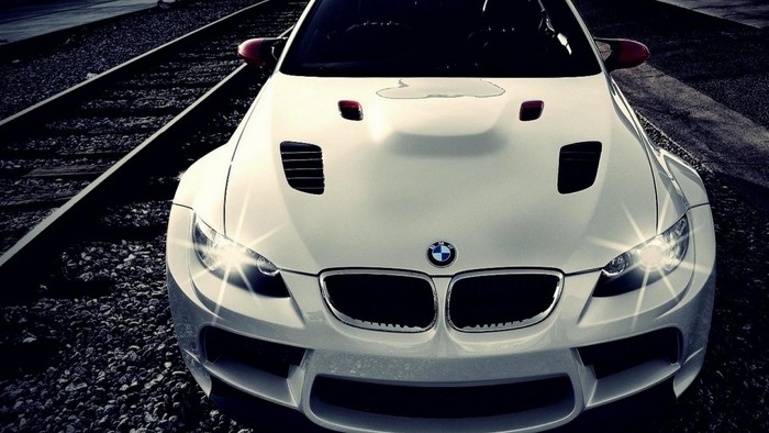 White BMW M3 on train tracks