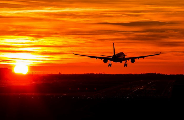 Airplane landing at sunset