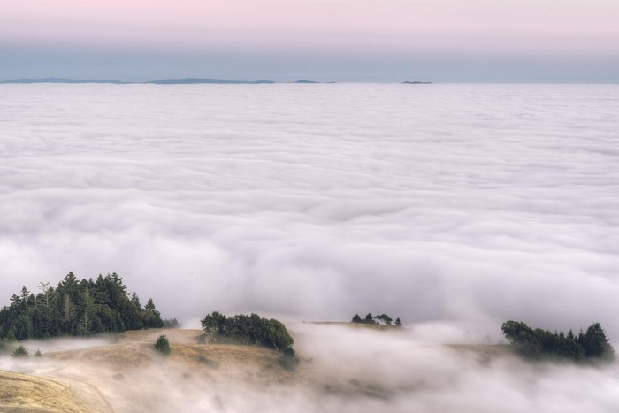 Foggy mountain landscape with clouds and distant islands