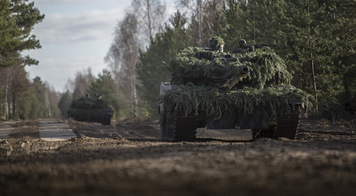 Leopard 2 tanks camouflaged in a forest
