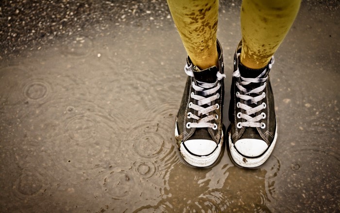 Converse sneakers in a puddle during rain