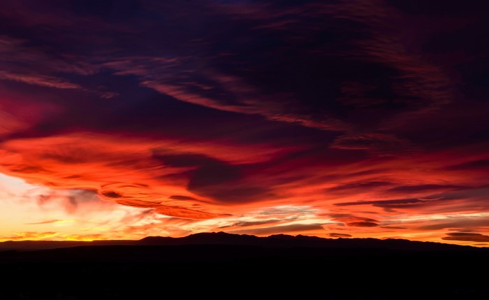 Dramatic sunset clouds over silhouetted mountains