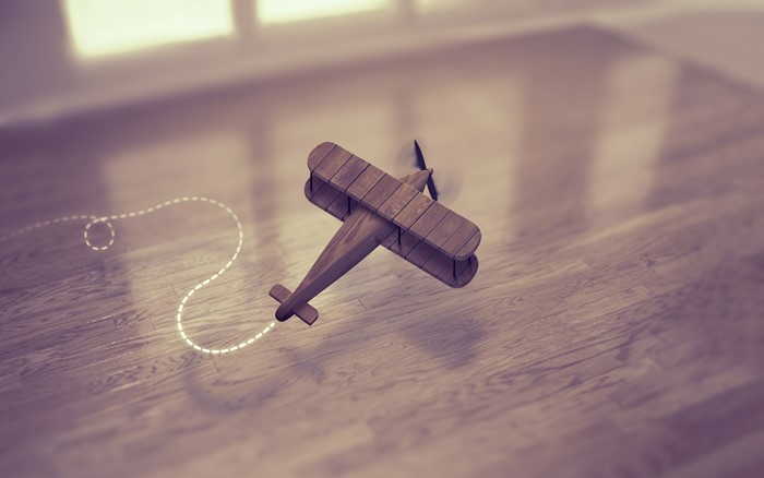 Wooden toy airplane flying on a wooden floor