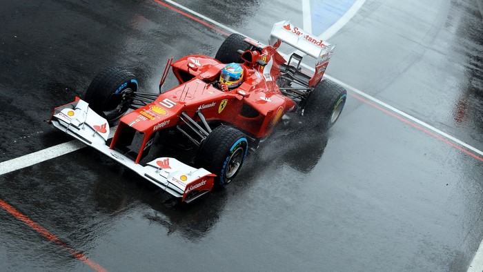 Fernando Alonso driving Ferrari F1 car in the rain