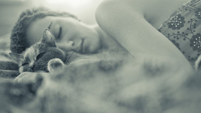Woman sleeping with a cat