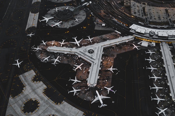 Aerial view of a busy airport terminal with many airplanes