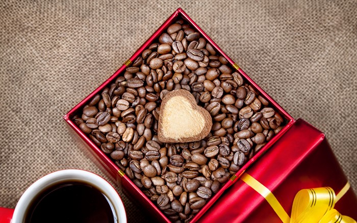 Coffee beans in a gift box with a heart cookie and coffee cup