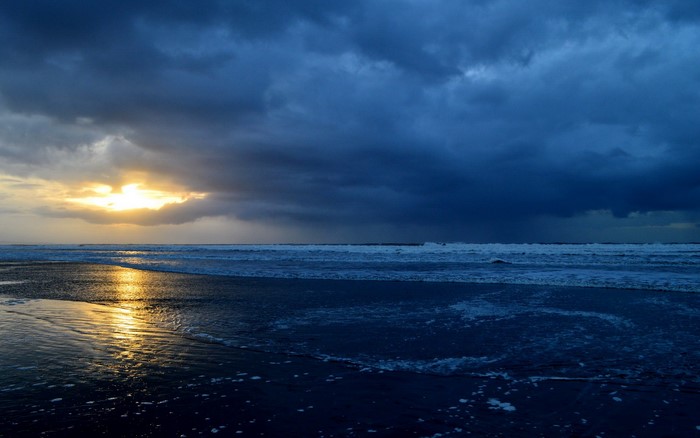 Sunset over a stormy beach with waves