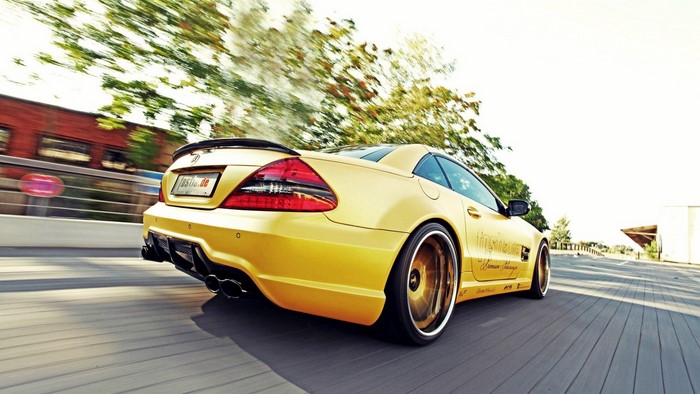 Yellow Mercedes SL-Class driving on a wooden boardwalk