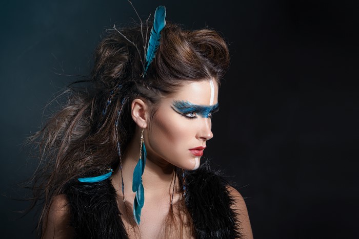 Woman with blue feather makeup and earrings