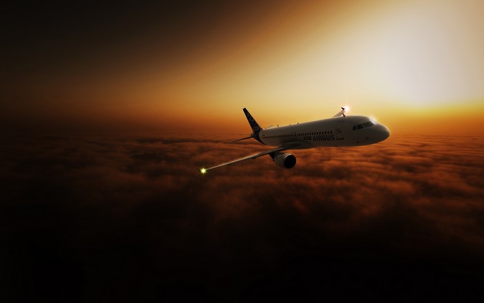 Airbus A320 flying above clouds at sunset