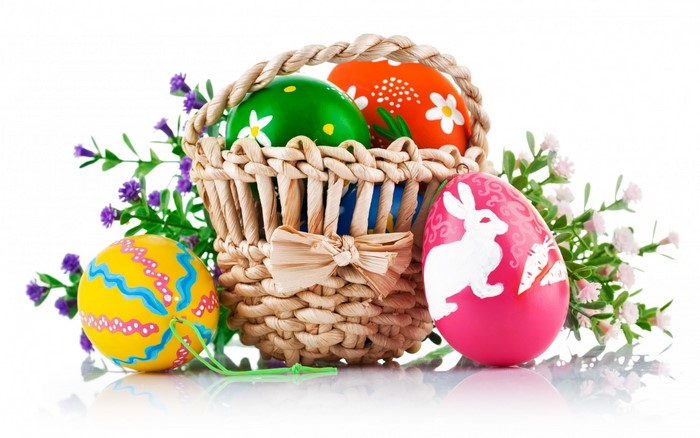 Easter basket with colorful decorated eggs and flowers