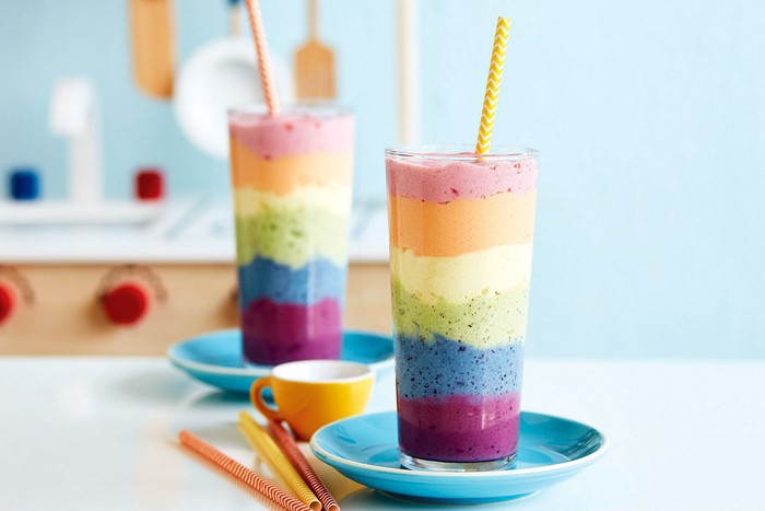 Rainbow layered smoothies in tall glasses